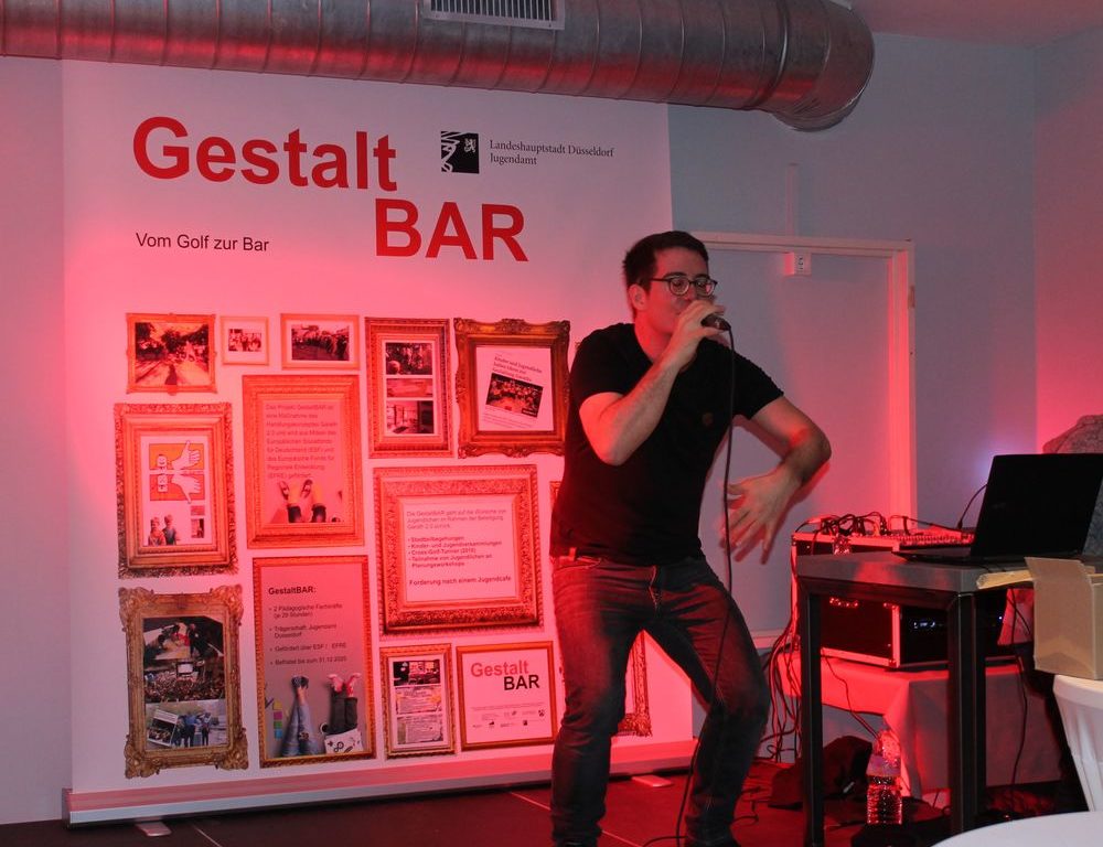 Die GestaltBAR in Garath ist eröffnet. Der Musiker MaximNoise aus Neuss zeigte, wie Jugendliche ihren neuen Ort nutzen können. Er performte einige seiner Lieder und animierte das Publikum zum Mitmachen. (Foto: youpod/Charlotte)
