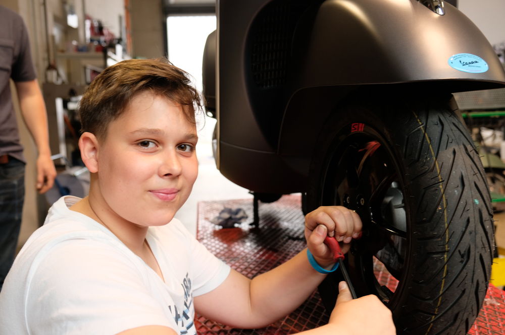 Nicht nur Theorie: Cassian darf in dem Vespa Betrieb auch anpacken. (Foto: Christina Behrens)