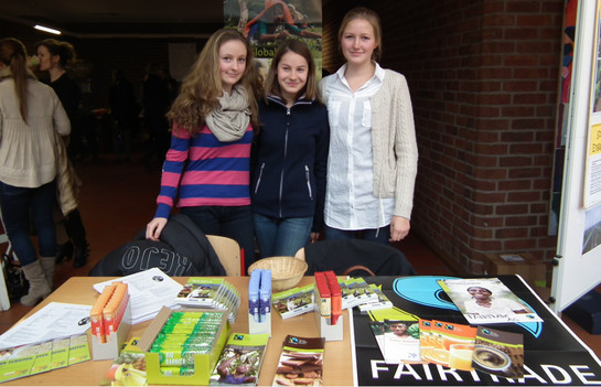 Drei Mitglieder der Fairtrade AG verkaufen Fairtrade-Produkte am Tag der offenen Tür im Foyer des Suitbertus- Gymnasiums. Benedikt Sondermann