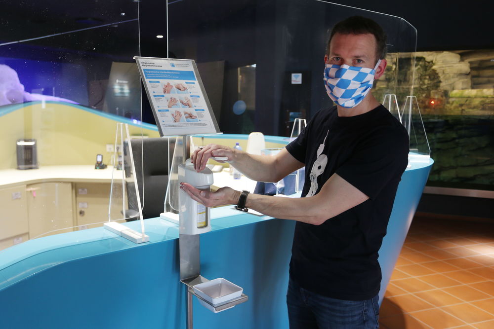 Aquazoo-Direktor Jochen Reiter im Kassenbereich des Instituts: Das Tragen einer Mund-Nasen-Bedeckung ist im Ausstellungsbereich Pflicht. Zudem wurden Plexiglasscheiben am Kassenbereich montiert. Desinfektionsmittelspender stehen ebenfalls bereit. (Foto: Landeshauptstadt Düsseldorf/David Young)